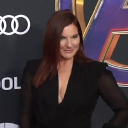 Ann Russo is wearing a black dress with a deep clevage.